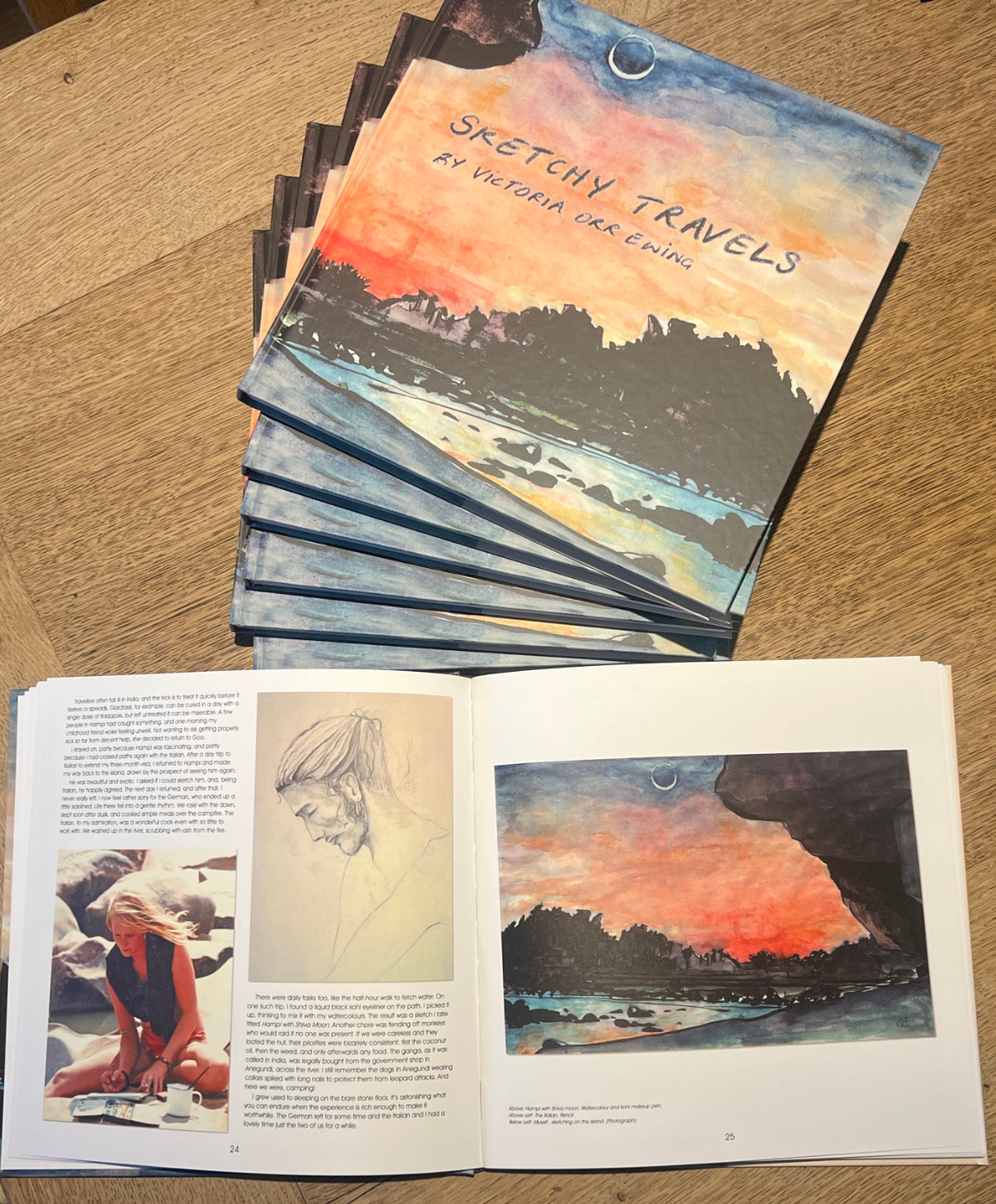 Copies of Sketchy Travels by Victoria Orr Ewing, with one book open to reveal illustrated pages of paintings and drawings.